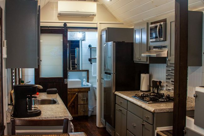 A kitchen with a sink , stove , refrigerator and microwave.