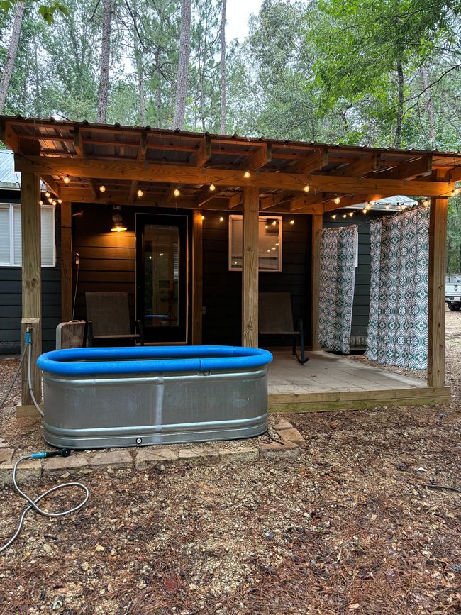 A small house with a hot tub in front of it.