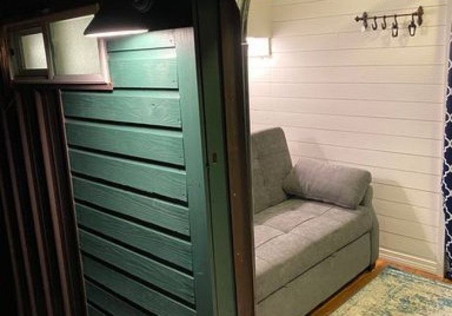 A couch is sitting in a room next to a door.