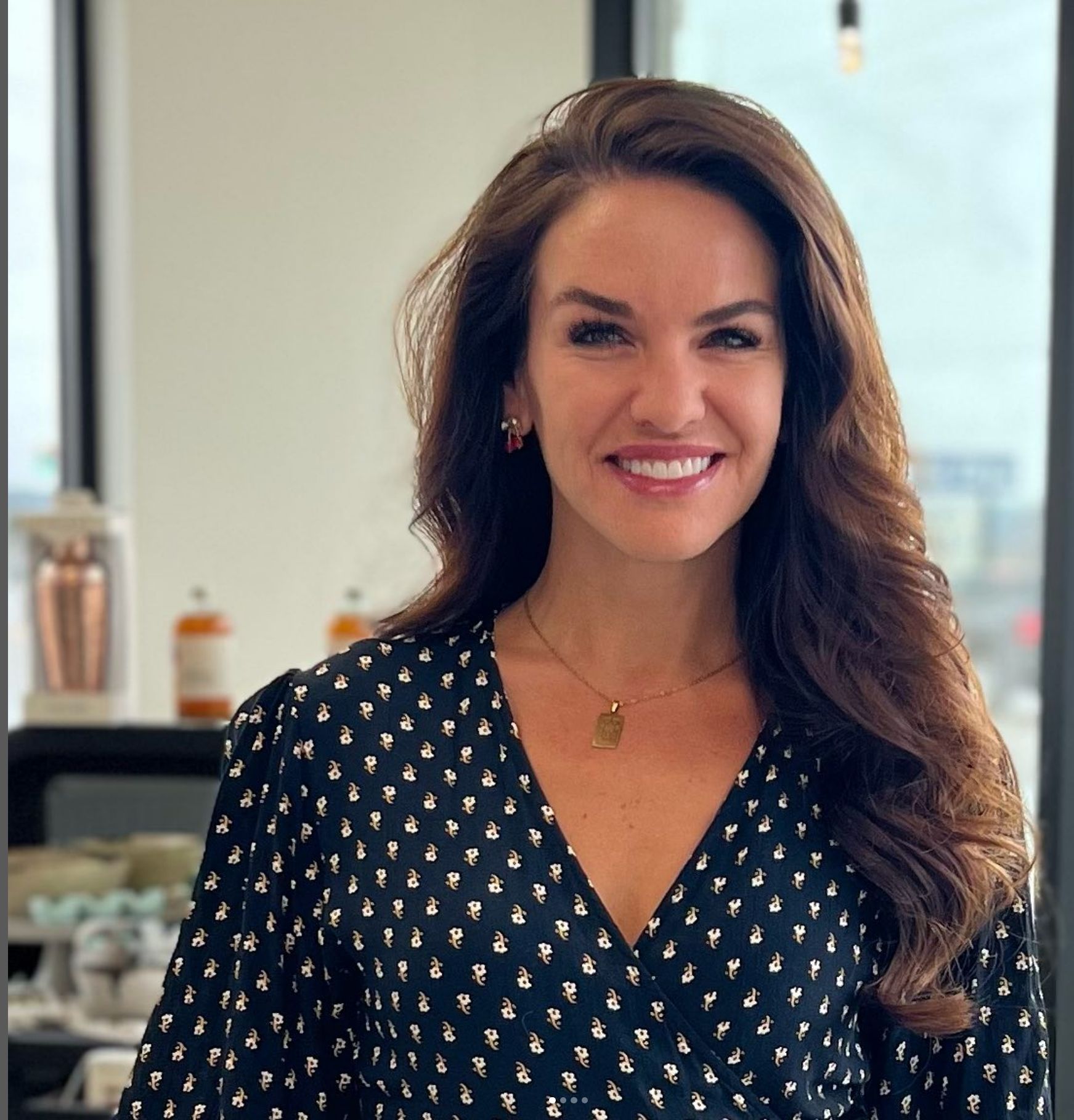 A woman in a polka dot dress is smiling for the camera
