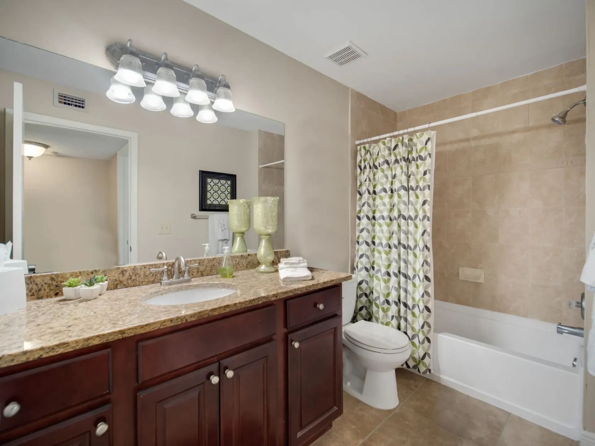 A bathroom with a sink , toilet , tub and mirror at Belvedere at Quail Run in Naples, FL.