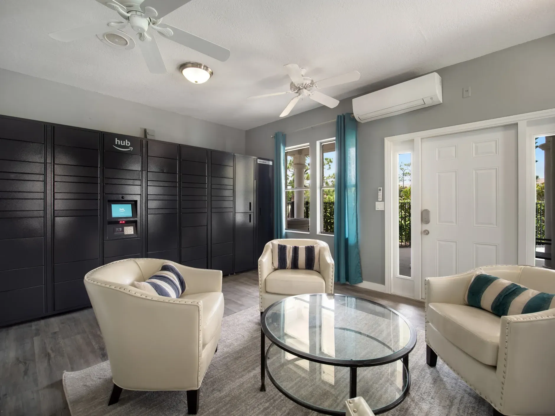 A living room with two chairs , a coffee table , and a ceiling fan at Belvedere at Quail Run in Naples, FL.