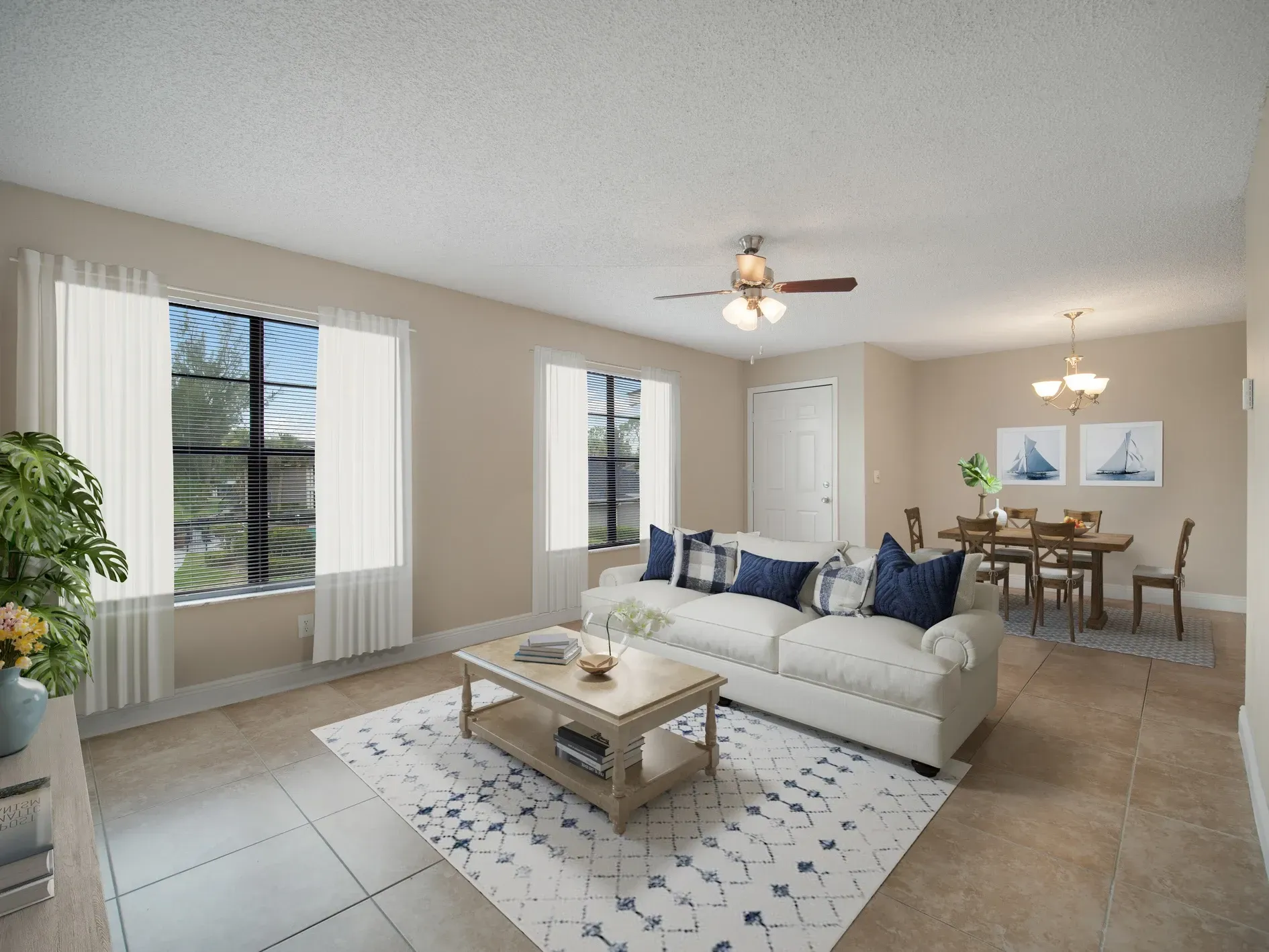 A living room with a couch , coffee table , and ceiling fan at Belvedere at Quail Run in Naples, FL.