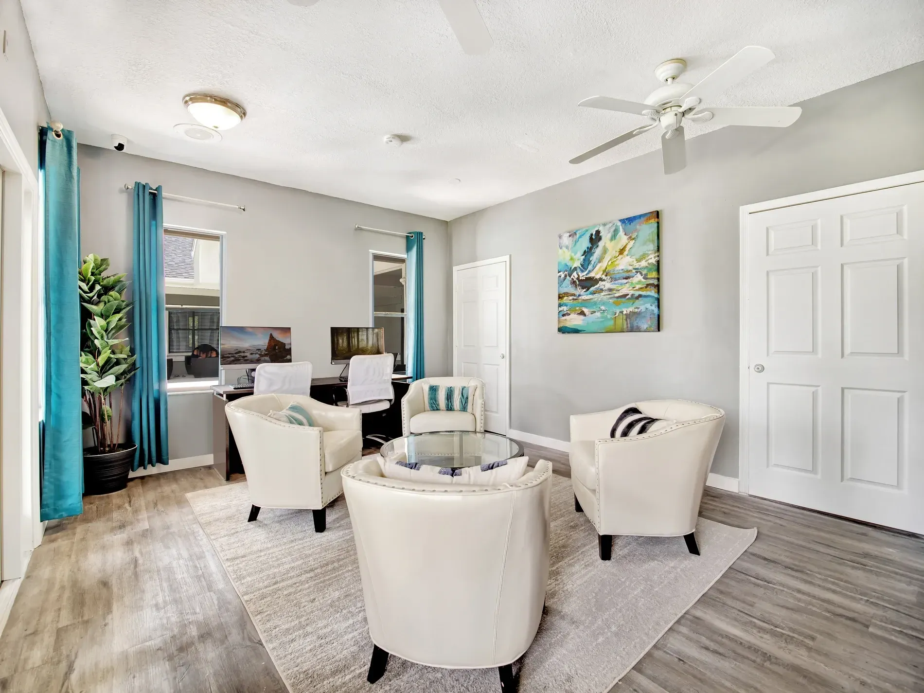 A living room filled with furniture and a ceiling fan at Belvedere at Quail Run in Naples, FL.