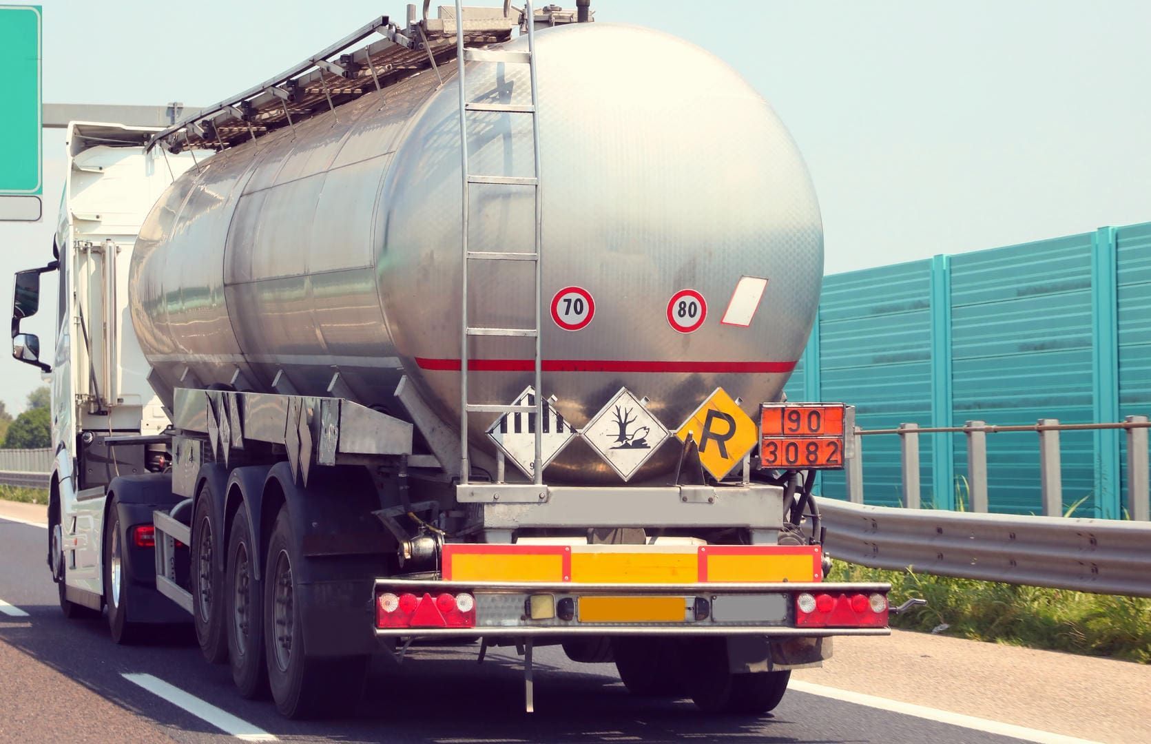 A tanker truck is driving down a highway.