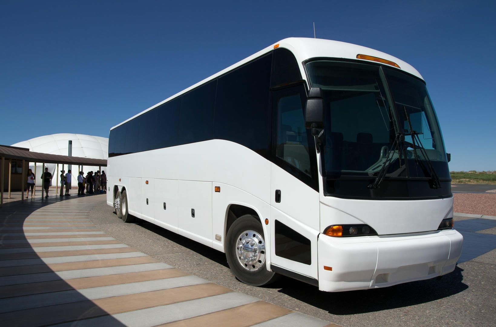 A large white bus is parked on the side of the road.