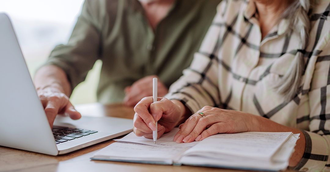 A person is writing on a piece of paper with a pen.