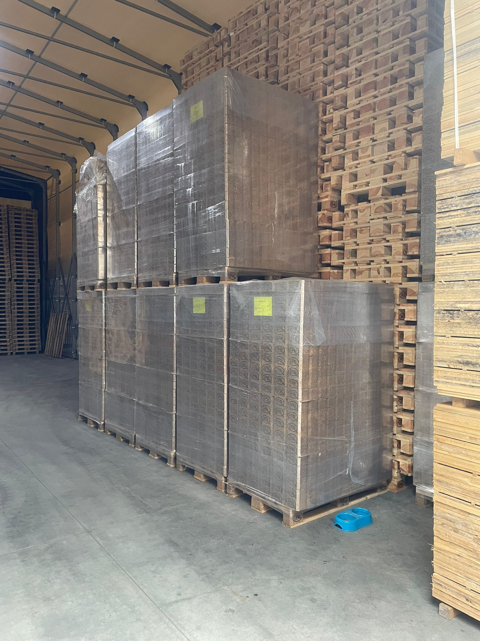 Pallet impilati con articoli rettangolari imballati in un magazzino.