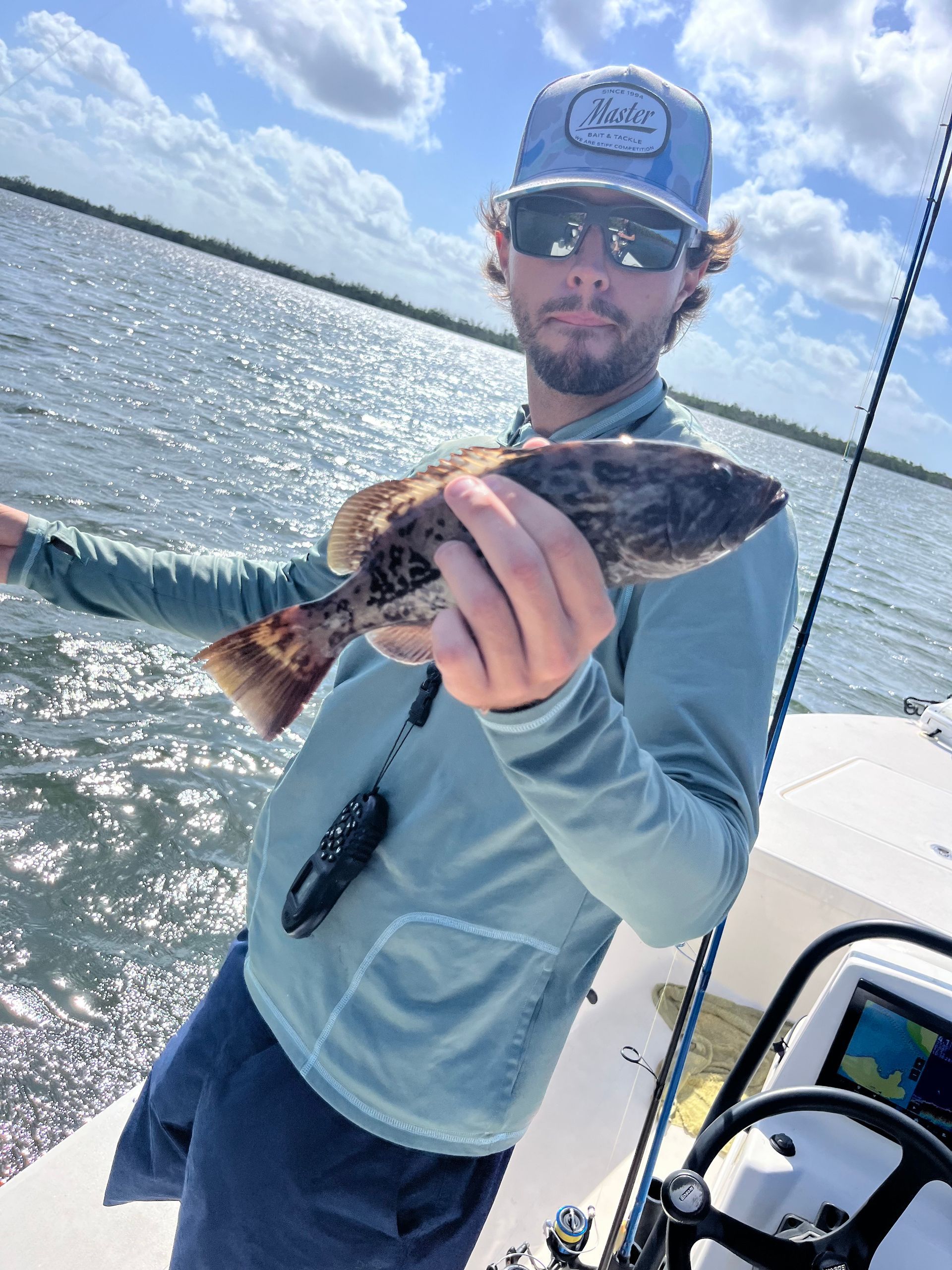 A man is holding a fish on a boat.