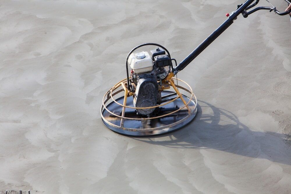A Person Is Using a Trowel on A Concrete Floor — Slippery Solutions In Cranbrook, QLD
