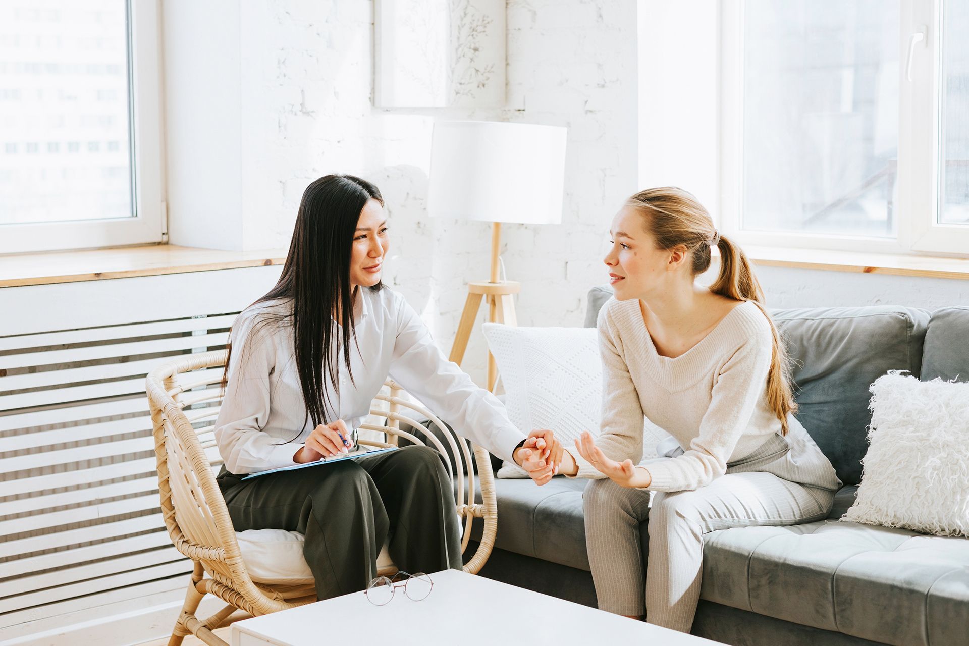 Therapist comforting a client on a sofa. 