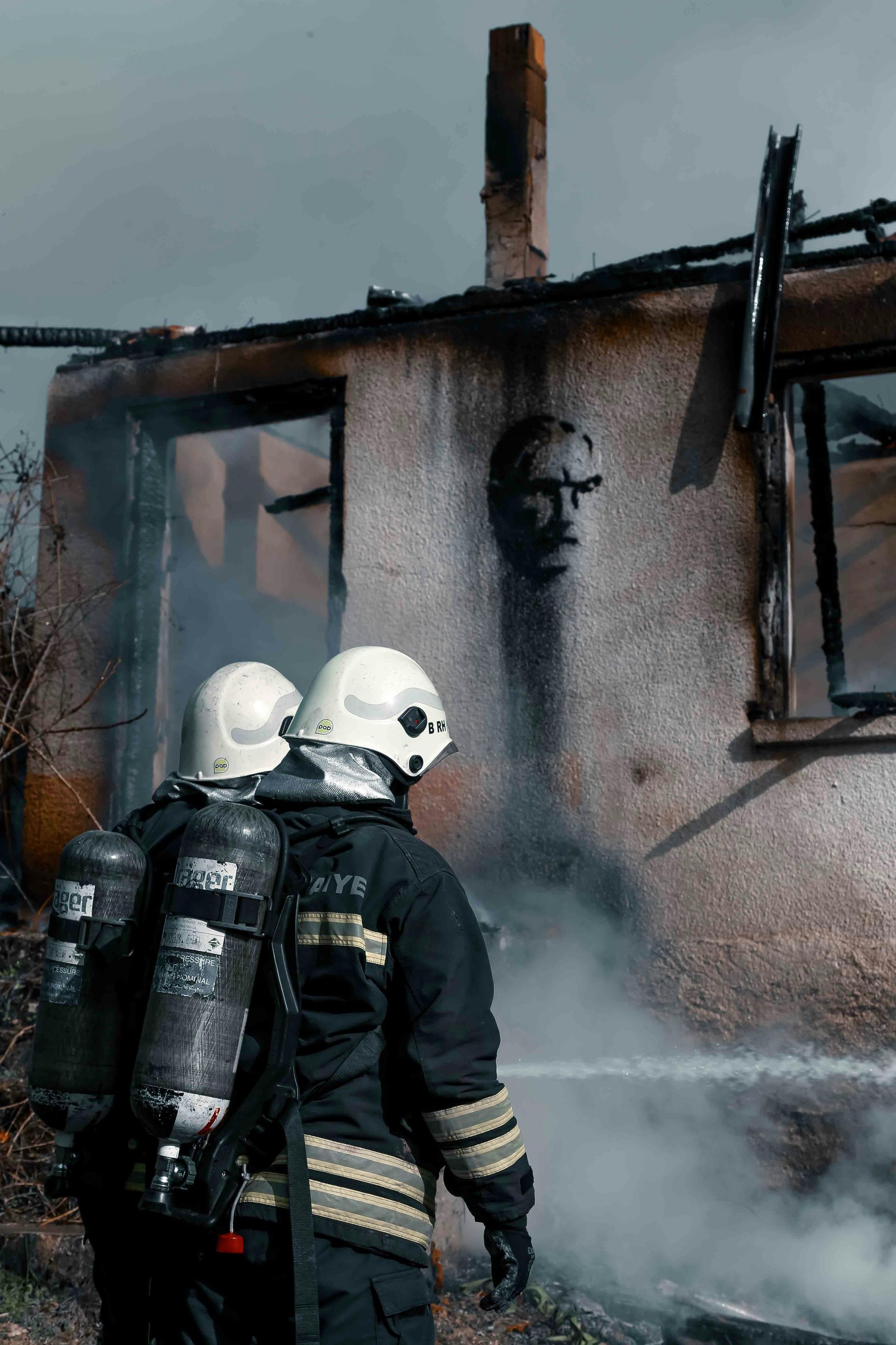 Homeowner inspecting fire-damaged living room with soot and smoke damage