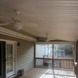 Covered porch with ceiling fans, screened-in area, wooden deck, and siding on house.