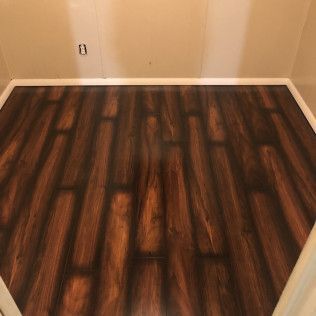 Dark brown wood-look flooring installed in a room with white trim and beige walls.
