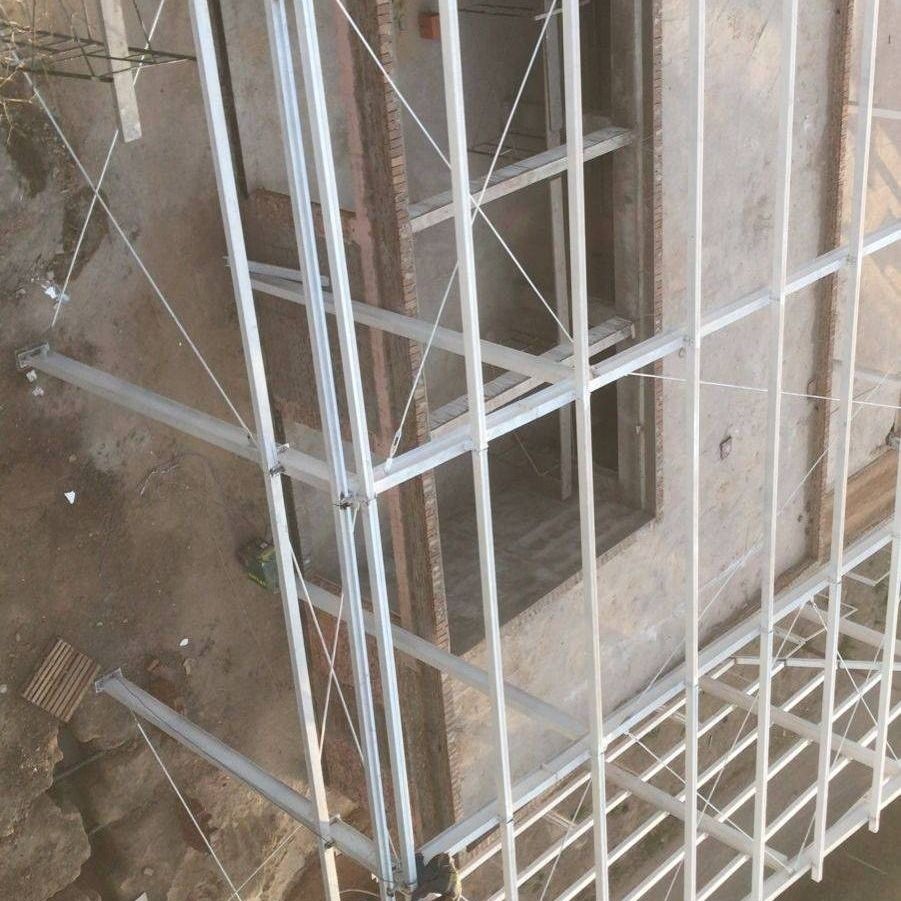 Andamios de construcción alrededor de una ventana de un edificio en una pared exterior alicatada.