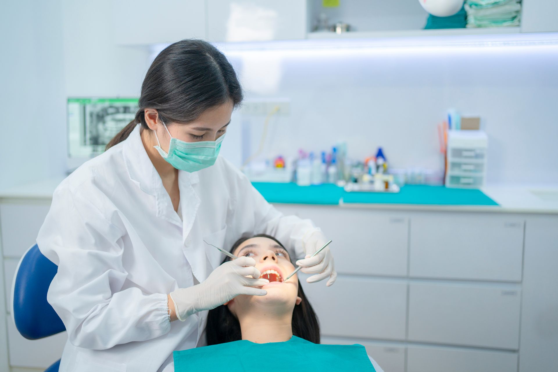 Dentist examining a patient’s mouth in a bright dental clinic