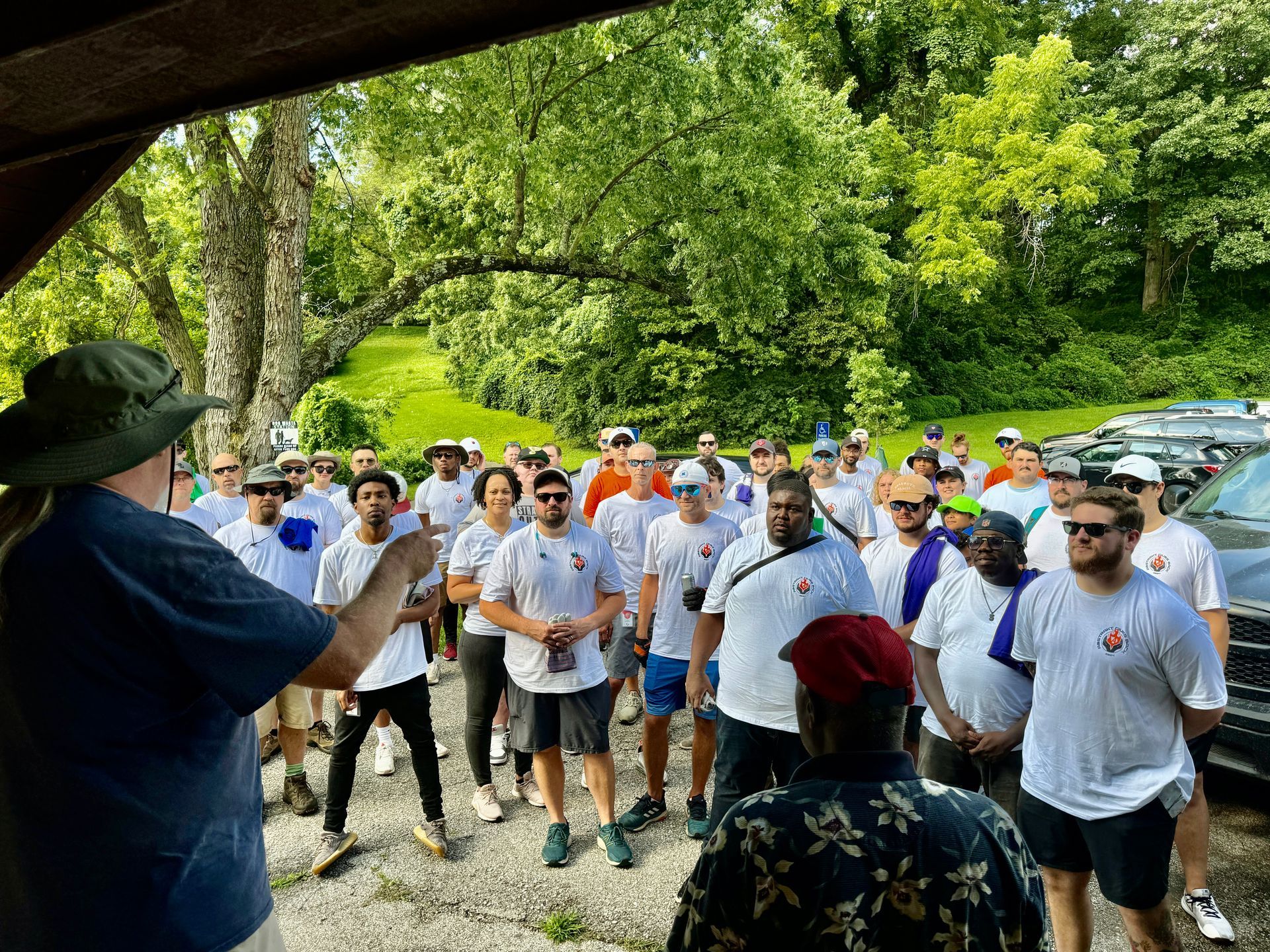 A man is standing in front of a large group of people.