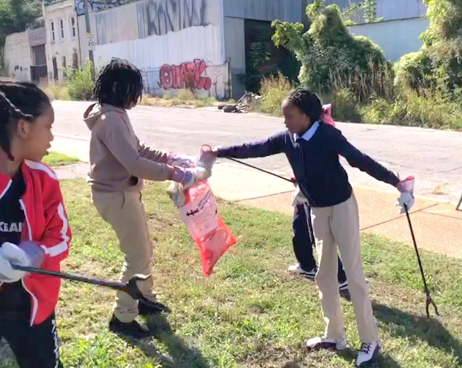 A group of children are picking up trash in a park.