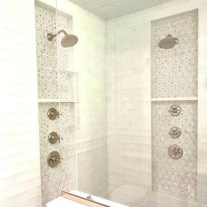 A bathroom with two showers and a toilet.