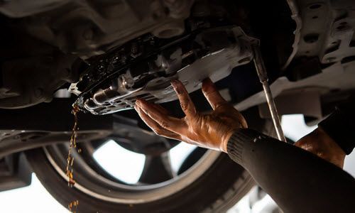Underneath of vehicle, flushing transmission fluid | Crowne Automotive