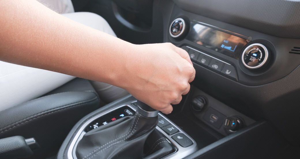 Up close to hand on the gear shift stick in vehicle | Crowne Automotive
