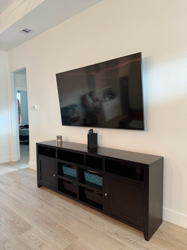 A flat screen tv is hanging on a wall and shows a screen that says great tv for nothing
