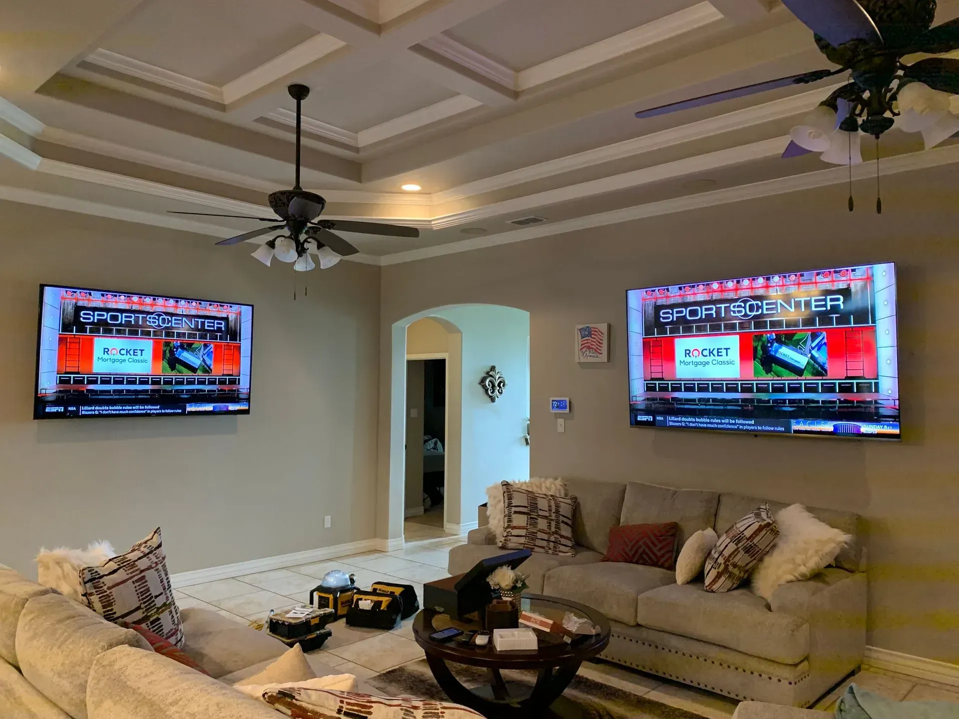 A living room with two flat screen tvs hanging on the wall.