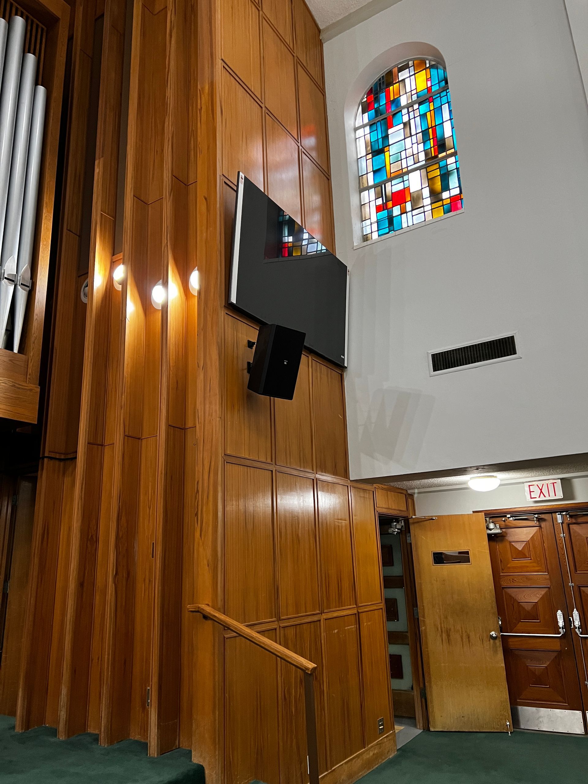 A church with a stained glass window and wooden walls