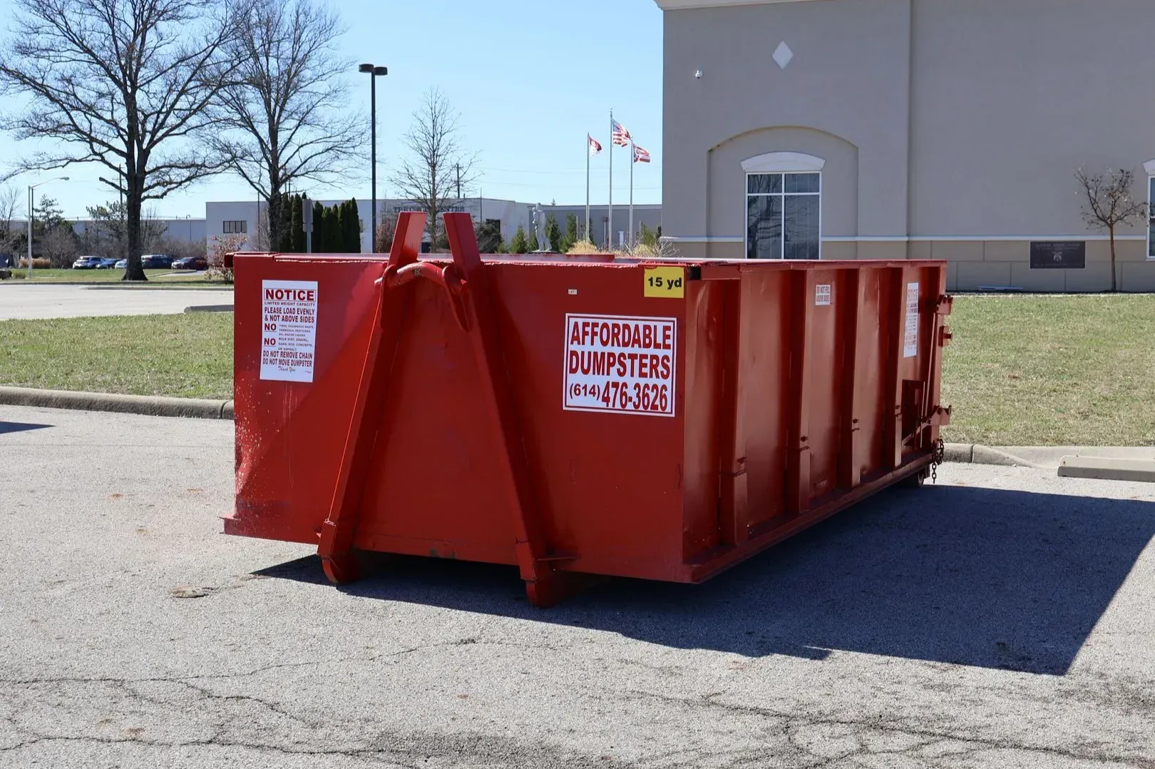 Red 15-yard roll-off dumpster in a parking lot, local dumpster rental services. Red 15-yard roll-off dumpster in a parking lot, local dumpster rental services.