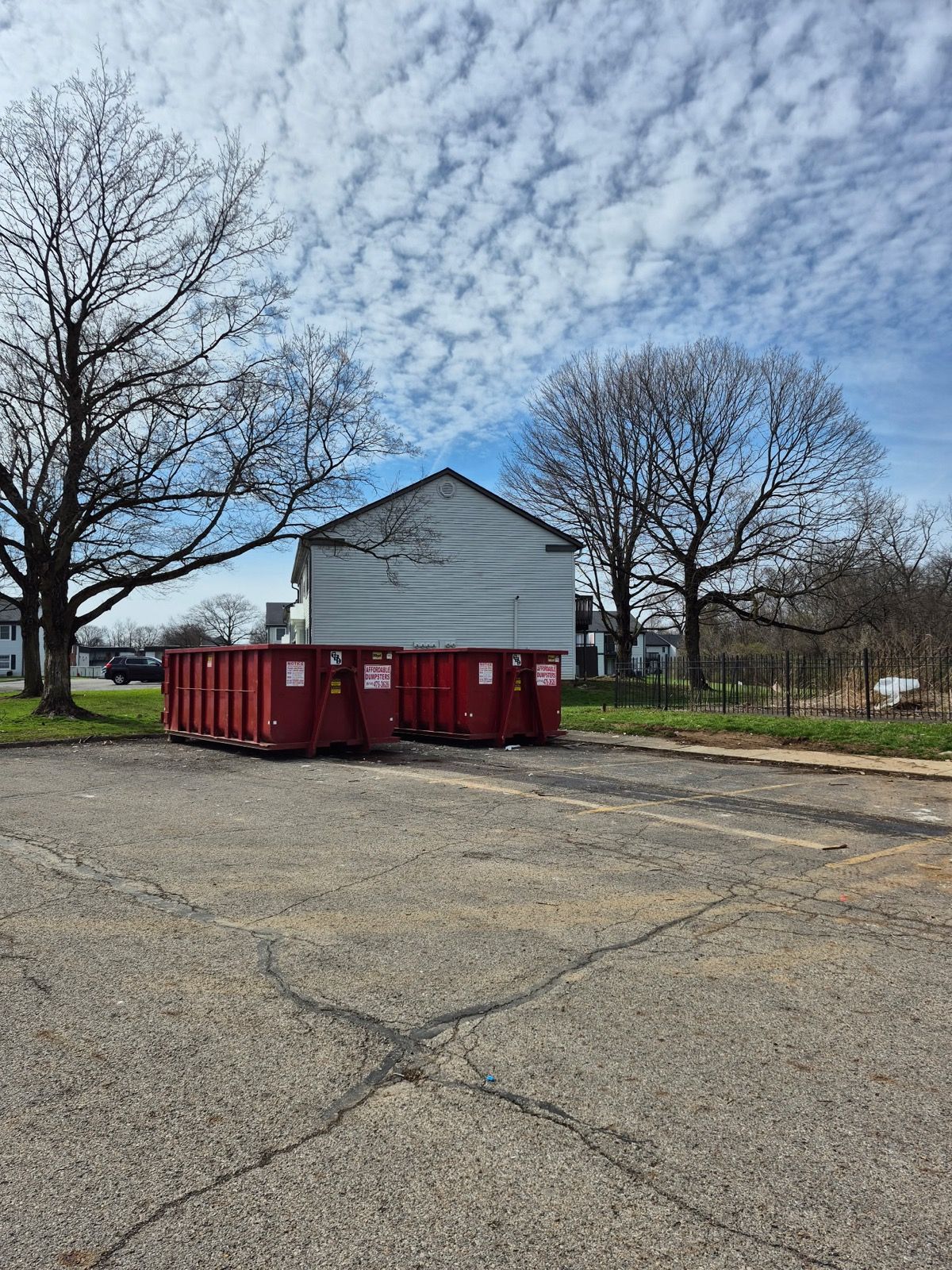 roll-off dumpster containers located in a parking area near a building roll-off dumpster containers located in a parking area near a building