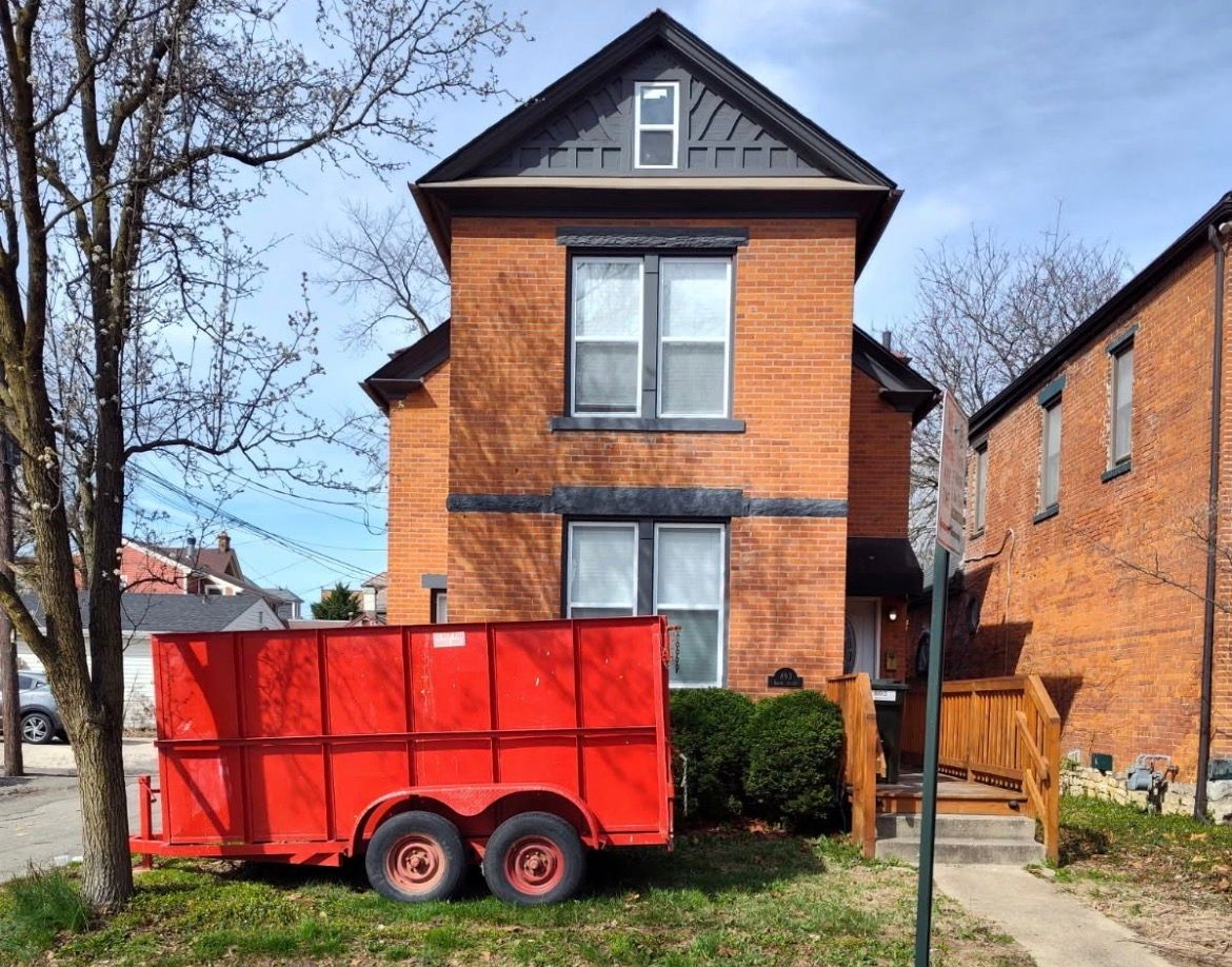 red dumpster trailer parked in the front yard