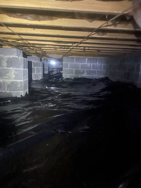 It looks like a flooded basement with a lot of black plastic on the floor.