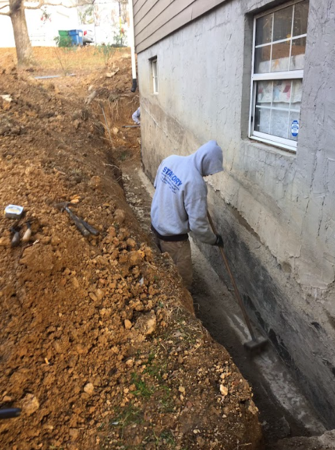 A man is working on the foundation of a house.