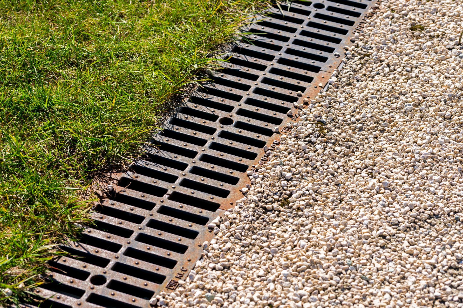 A clean storm drains with grass and gravel surrounding it. A clean storm drains with grass and gravel surrounding it.