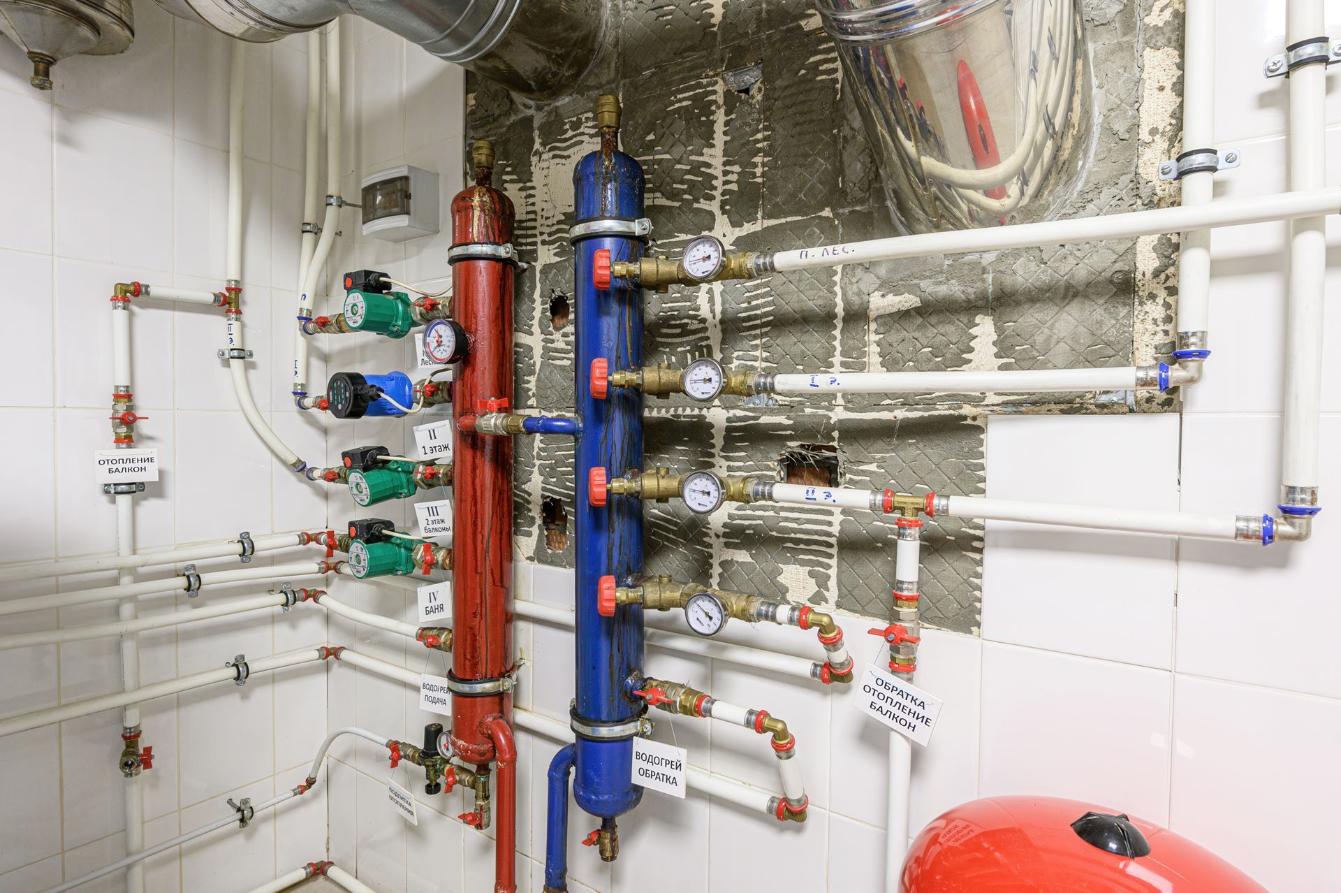 A complex plumbing system with pipes, gauges, pumps, and tanks in a tiled room. A complex plumbing system with pipes, gauges, pumps, and tanks in a tiled room.