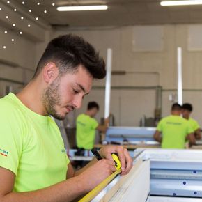 Un uomo che misura un pezzo di legno con un metro a nastro