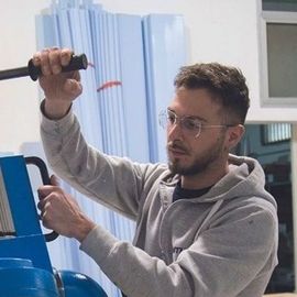 Un uomo che indossa gli occhiali sta lavorando su una macchina