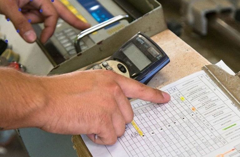 Una persona indica un telefono cellulare su un tavolo.