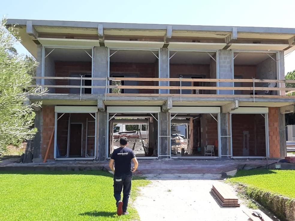 Un uomo cammina davanti a un edificio in costruzione.