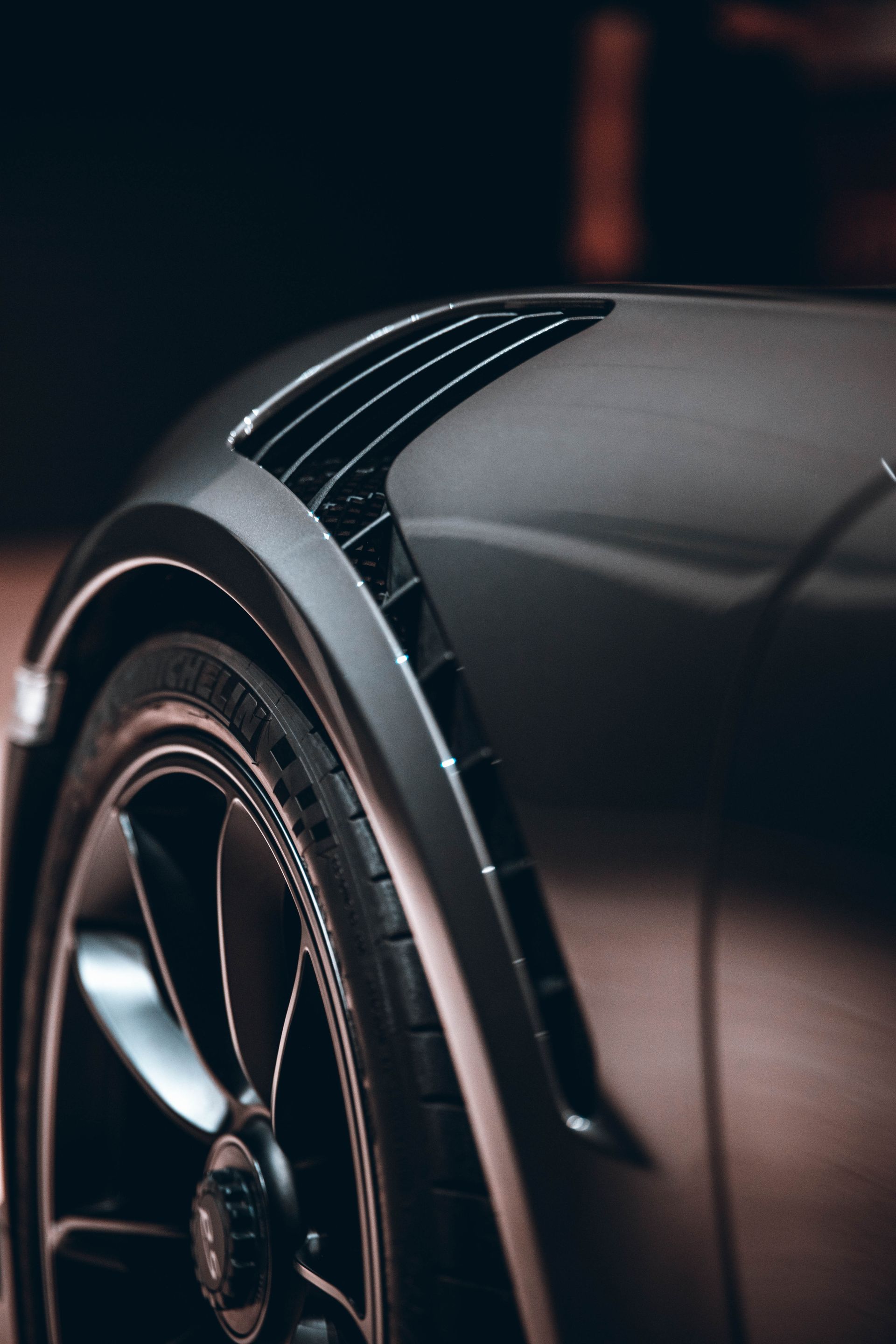 A close up of a car 's wheel and fender.