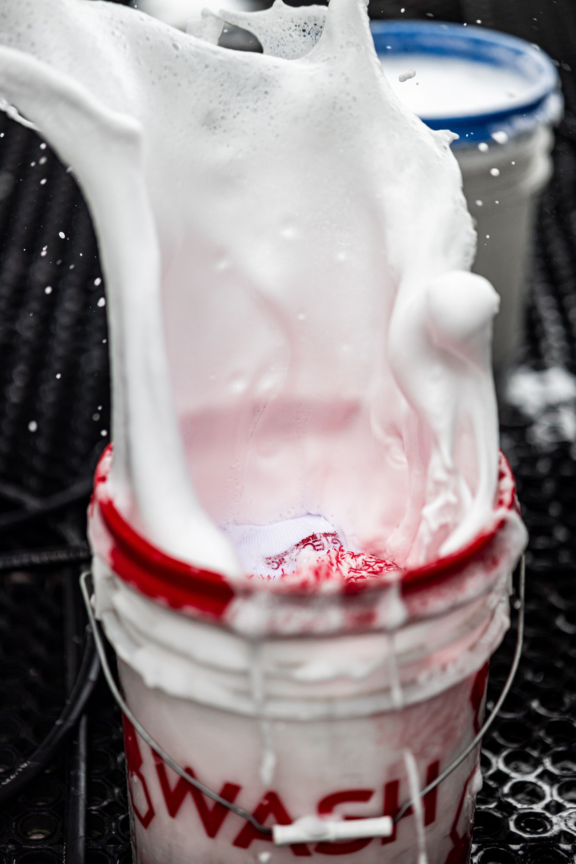 A bucket of foam is being poured into another bucket.