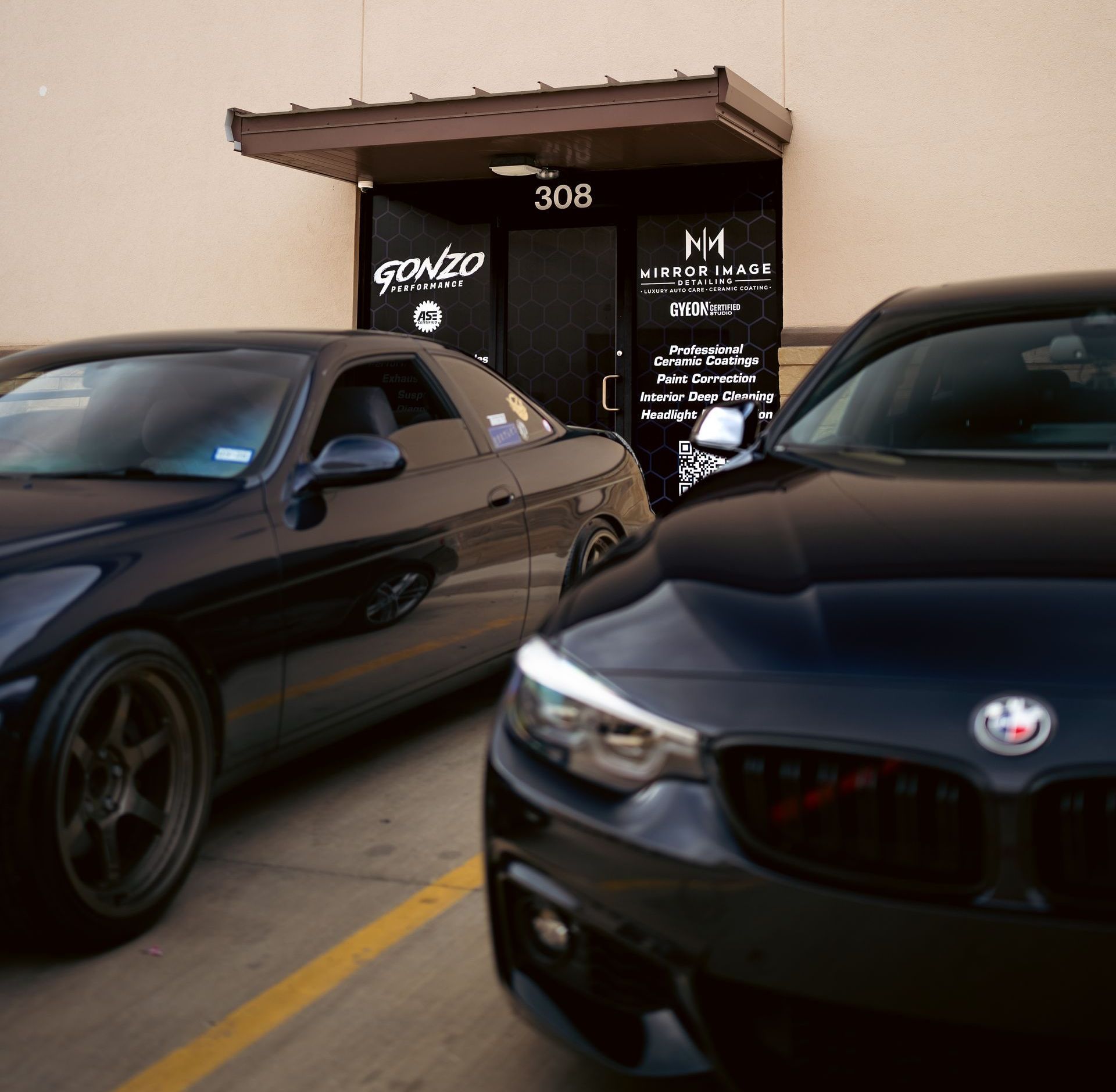 Two cars are parked in front of a store called gonzo