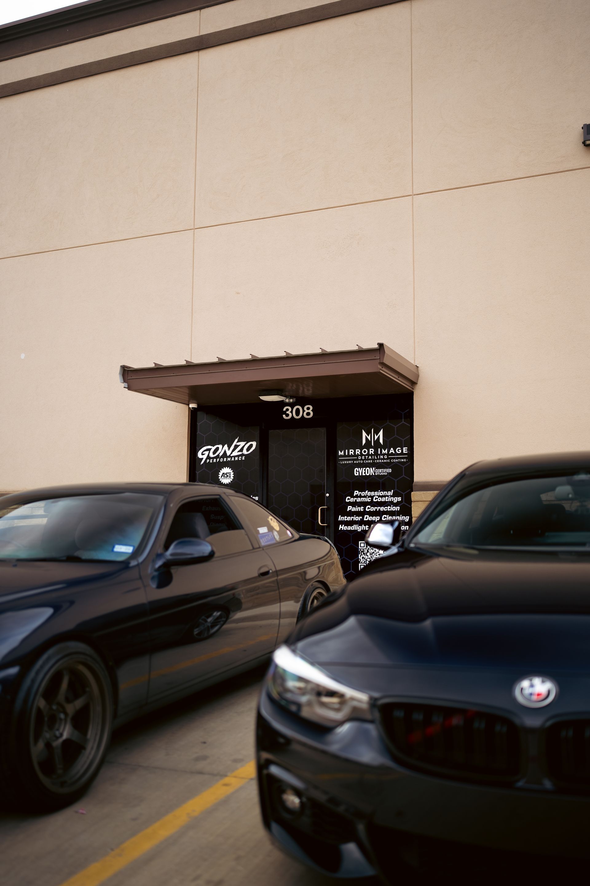 A couple of cars are parked in front of a building.
