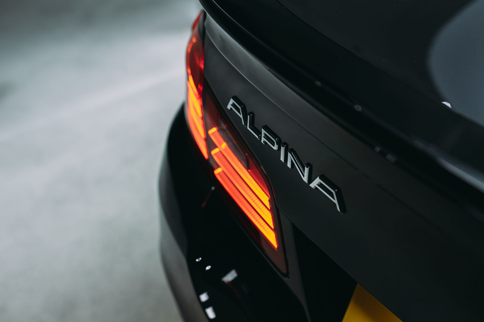 A close up of the back of a black alpina car