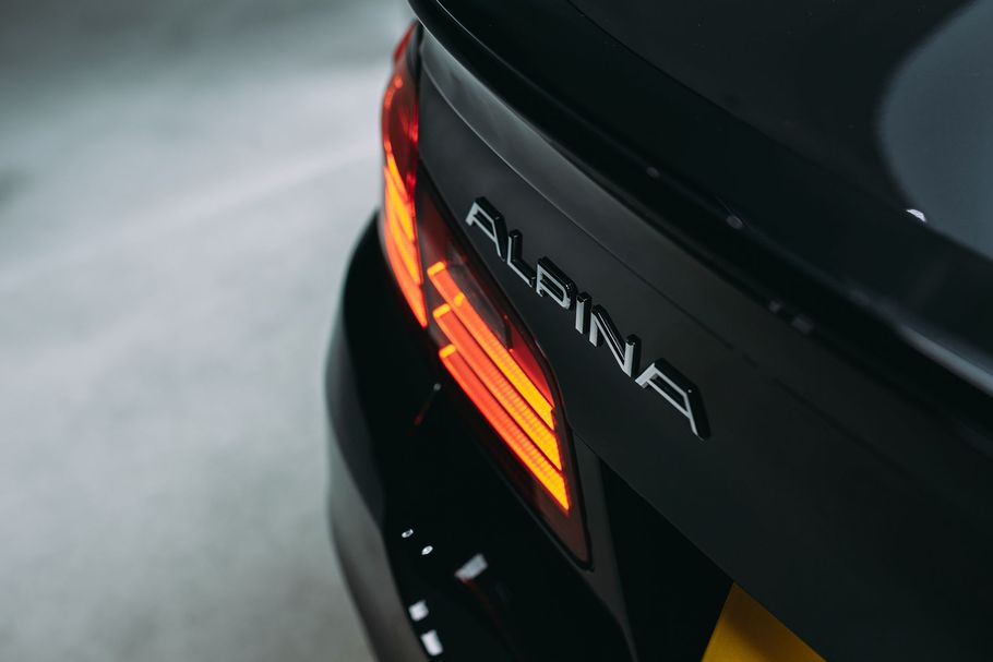 A car is sitting under a heat lamp in a garage.