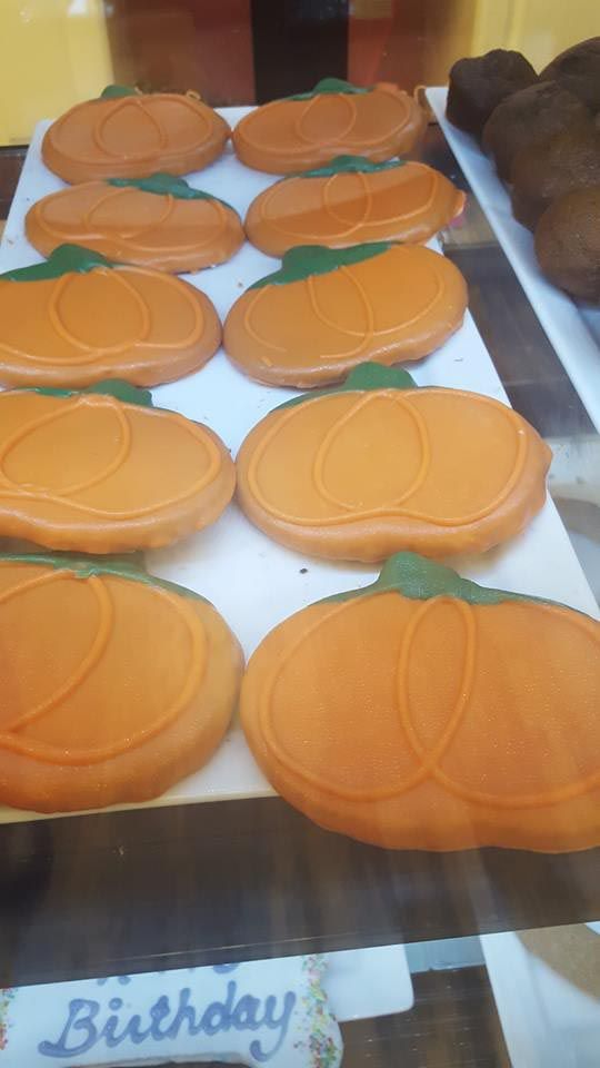 A tray of cookies in the shape of pumpkins on a table.