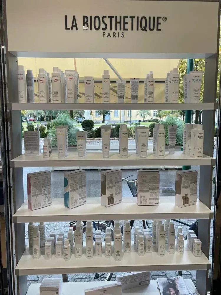 Espositore per prodotti per la cura della pelle di La Biosthétique Paris con file di flaconi bianchi sugli scaffali.