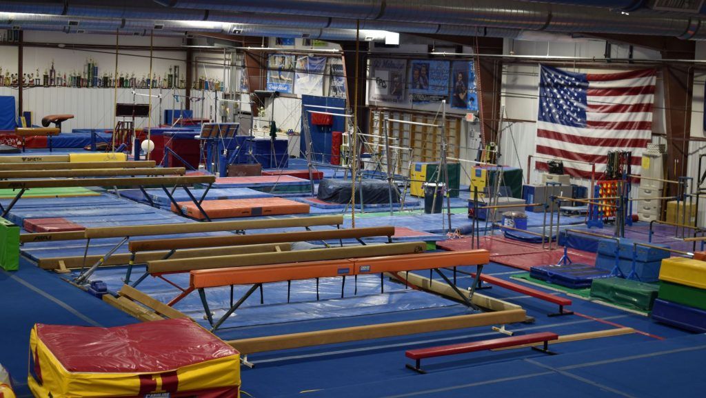 A large gym filled with lots of equipment and an american flag.