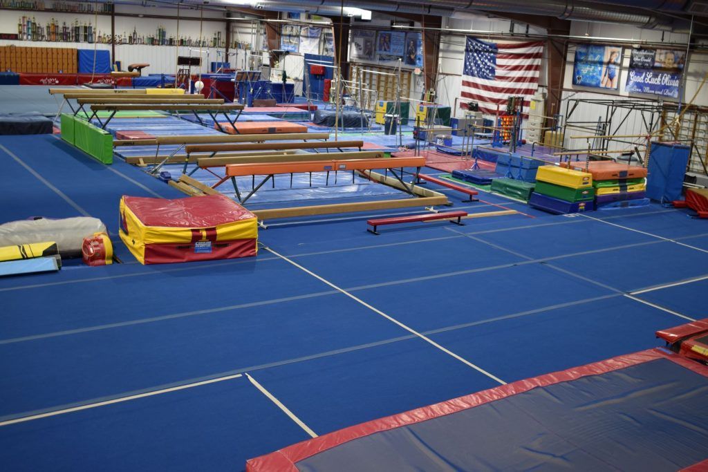 A large gym filled with lots of equipment and a large american flag.