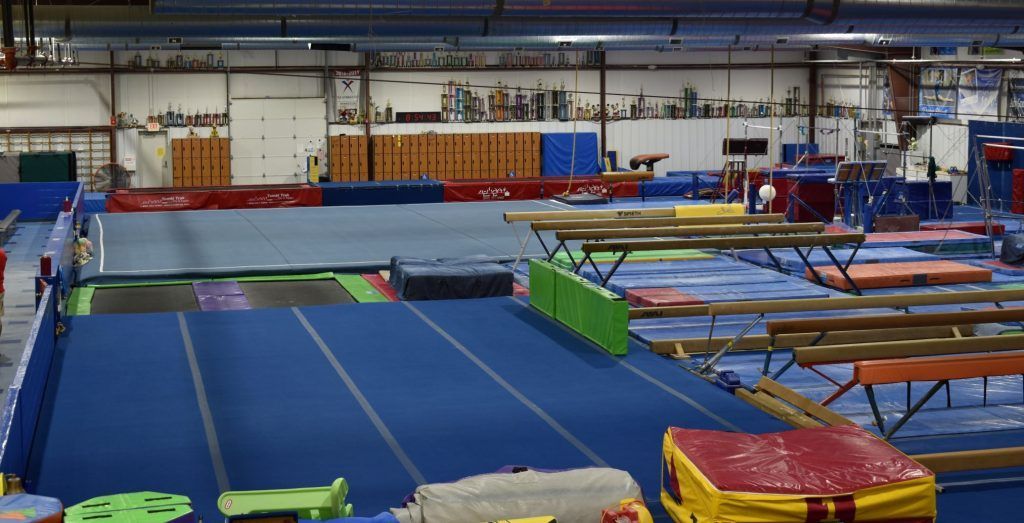 A gym filled with lots of equipment and a trampoline.